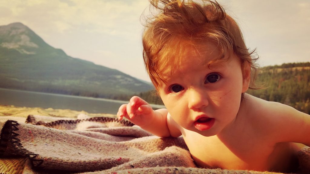 naked baby outside on the beach