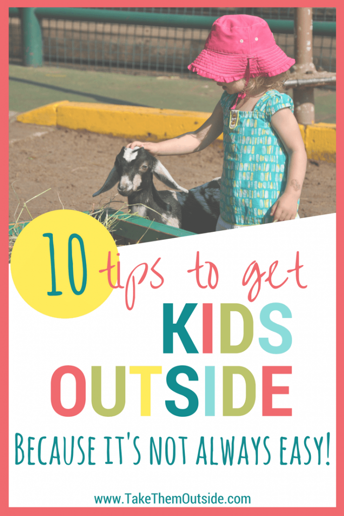 Young toddler wearing a pink sunhat petting a baby goat - text reads: 10 tips to get kids outside because it's not always easy
