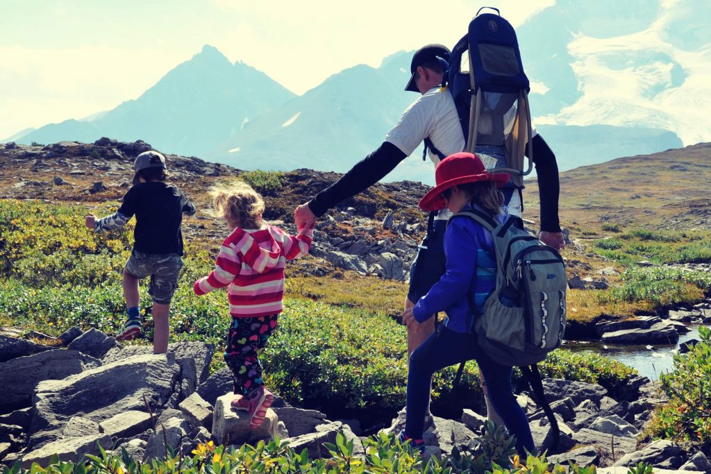A dad and 3 kids on a family hike in the mountain alpine of Jasper National Park, Canada