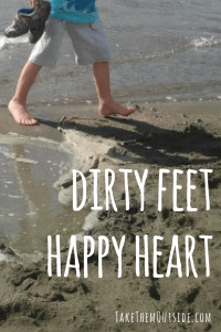 boy walking along the beach barefooted. text reads "dirty feet happy heart"