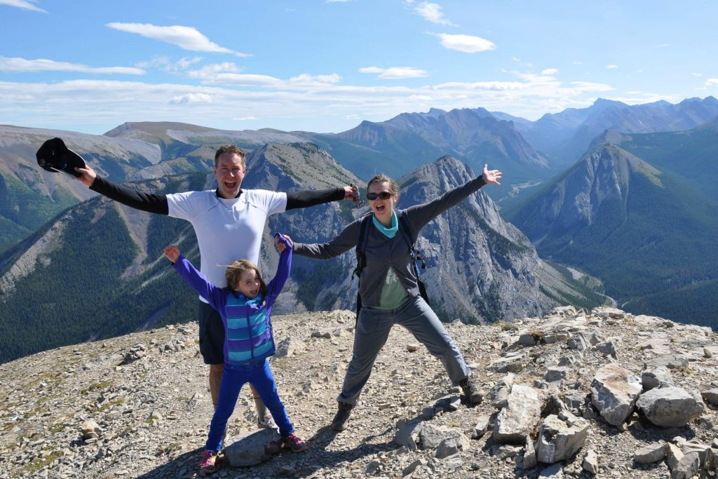 A mom, dad, and young girl standing a top Sulpher Skyline in Jasper National Park