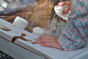 baby hands pressing down on a pizza box solar oven