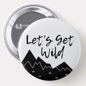 A white button with black mountains, script reads Let's Get Wild