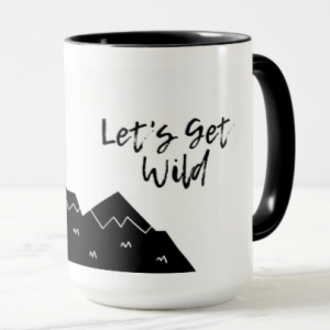 A white mug with black mountains and the words Let's Get Wild in script