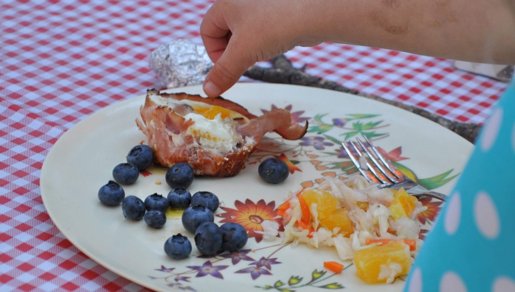 cooked ham and egg cups on a caping plate with blueberries and coleslaw