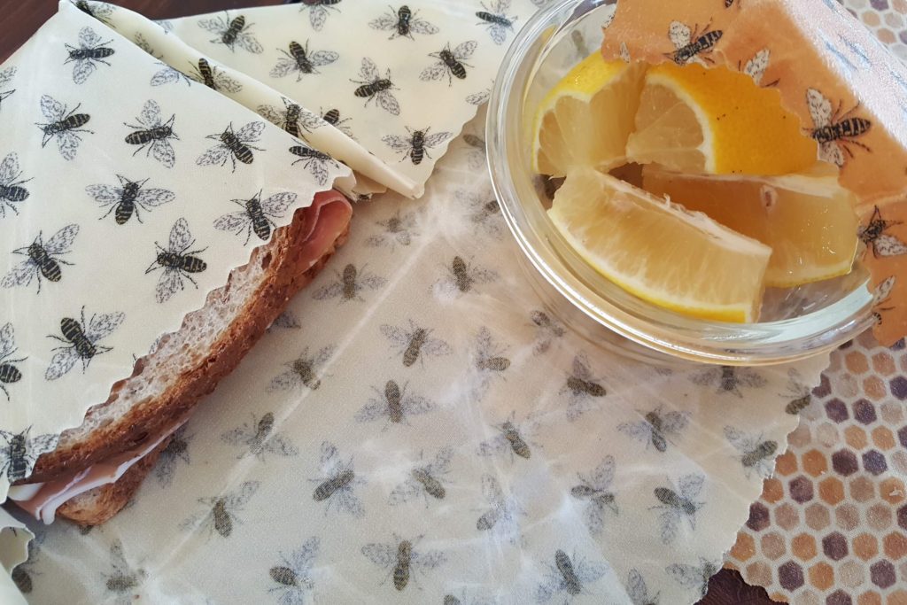 A sandwich and glass bowl waiting to be covered with beeswax wraps