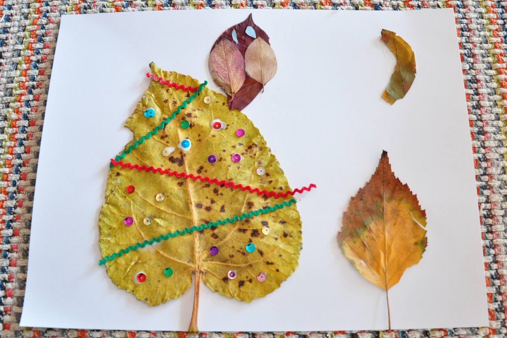 A kid's leaf art project. It's an owl sitting on a tree with the moon overhead