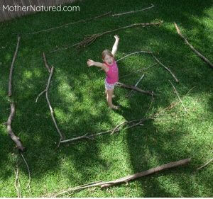 a girl standing in the middle of a stick maze