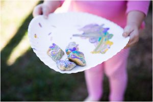 a young child holding a paper plate with painted rocks