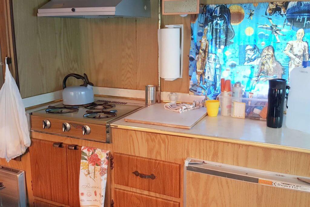 The counter and stove top inside a vintage rv camper triailer