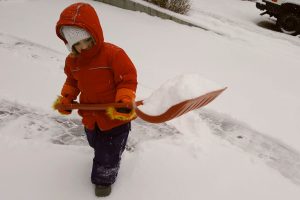 a preschooler shoveling snow 