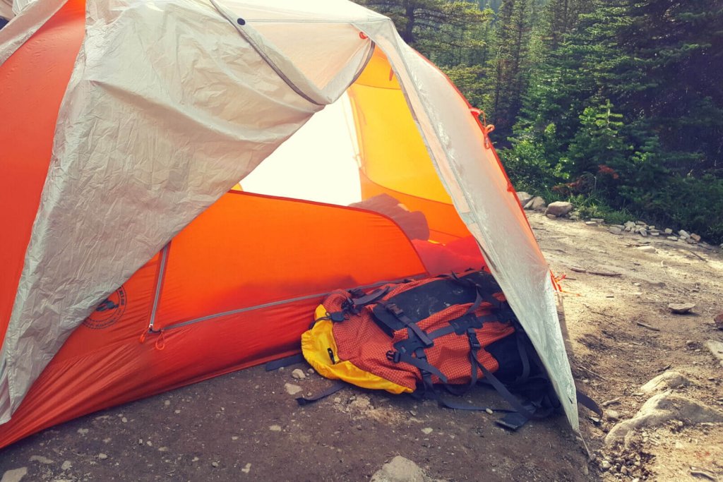 An orange tent and backpack