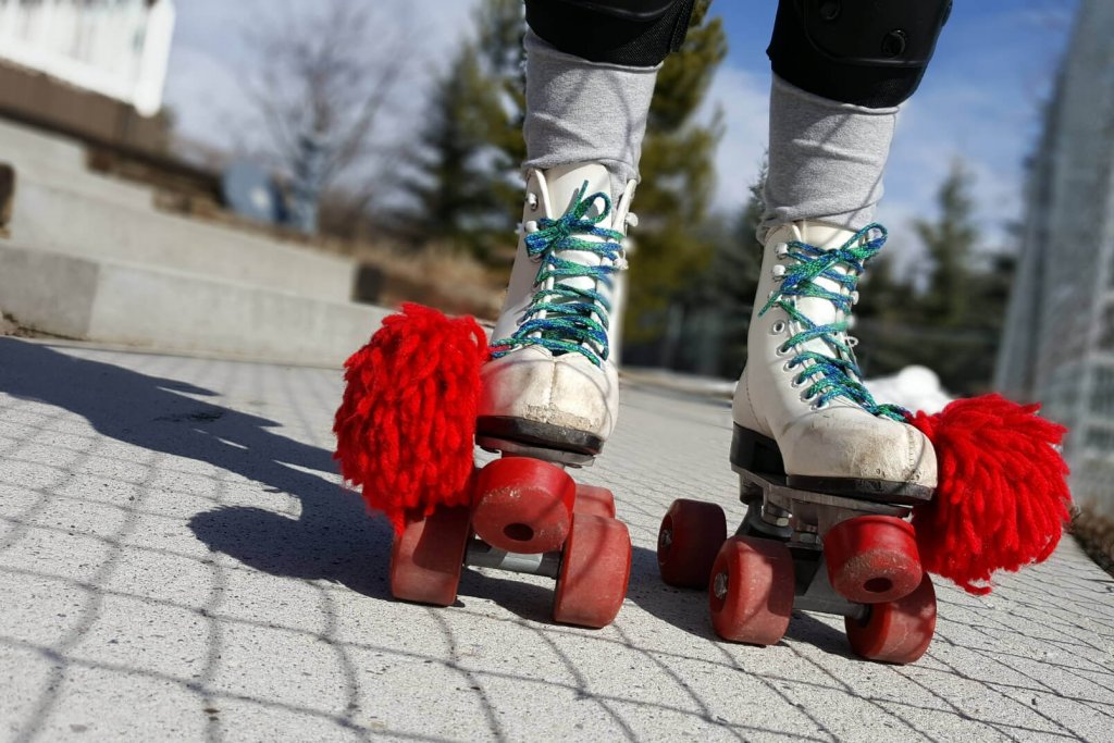 white roller skates with a red pompom