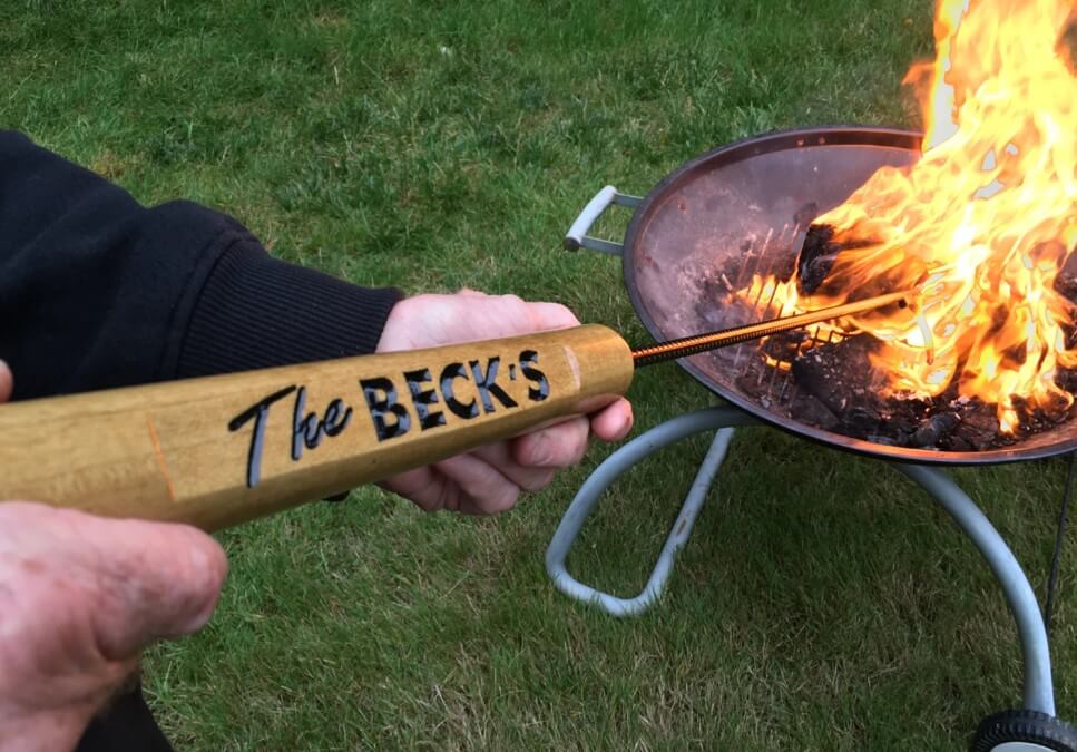 Someone using a personalized fire poker in a fire pit