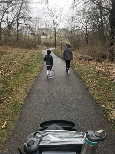 kids walking on a paved park path in rainy weather