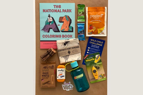 various snacks, outdoor gear, coloring book that kids will receive in the wild child box