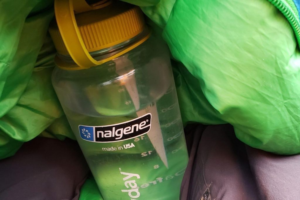 a heated water bottle in a sleeping bag