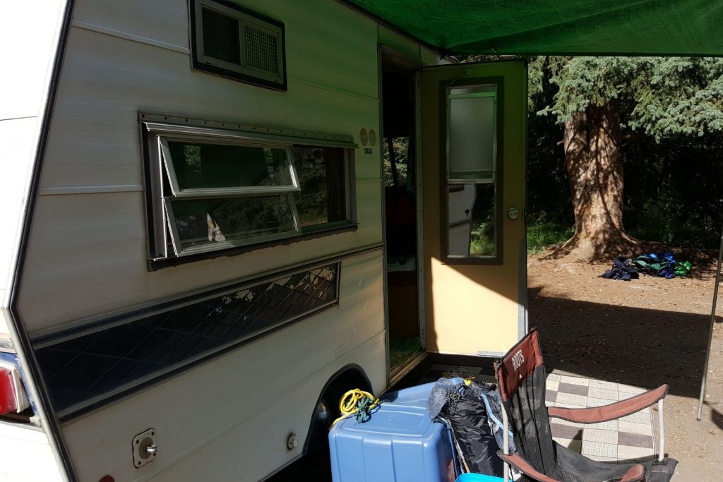 A vintage travel trailer set up at the campsite