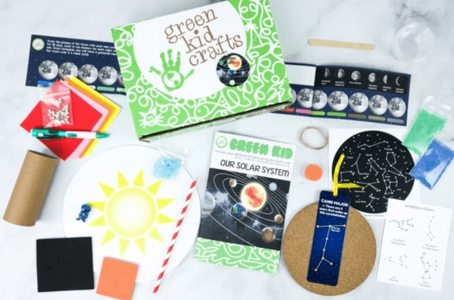 various art and science items in a space themed green kids craft subscription box