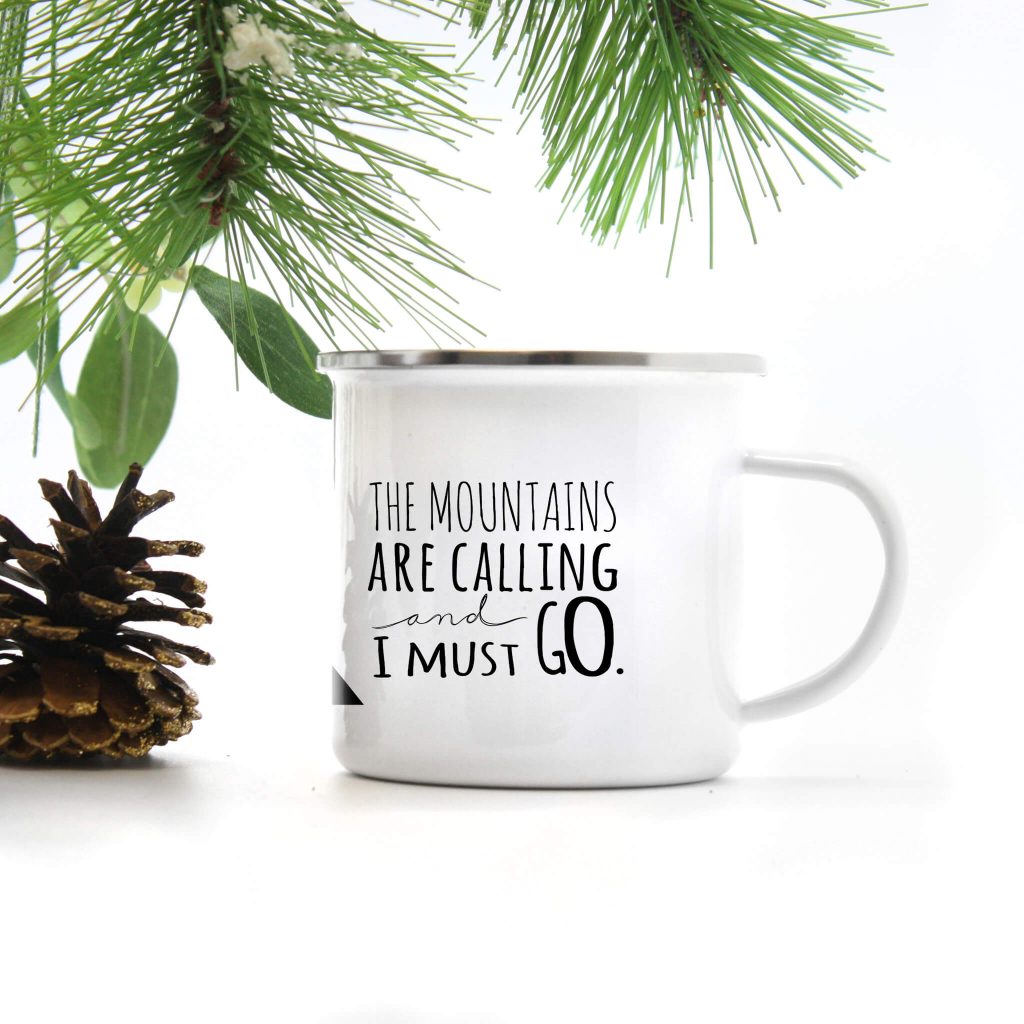 white enamel camp mug which reads the mountains are calling and I must go