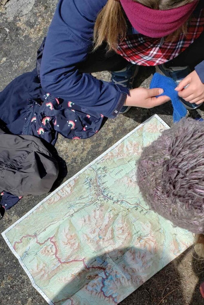 kids kneeling down and looking at a map