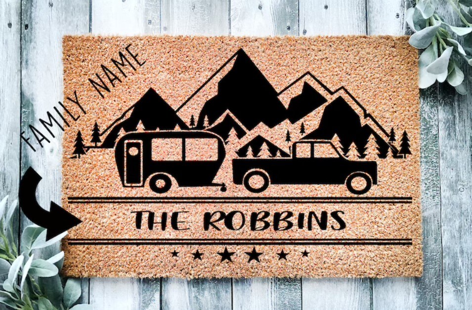 a personalized door mat with a picture of mountains and a camper