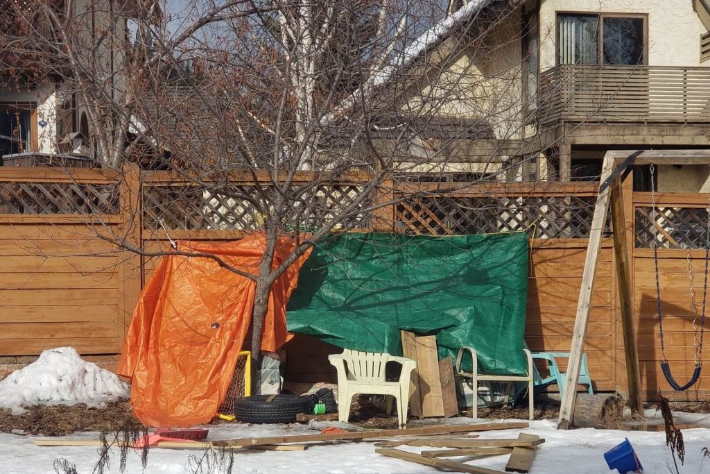 a fort made my an only child using tarps and random backyard pieces