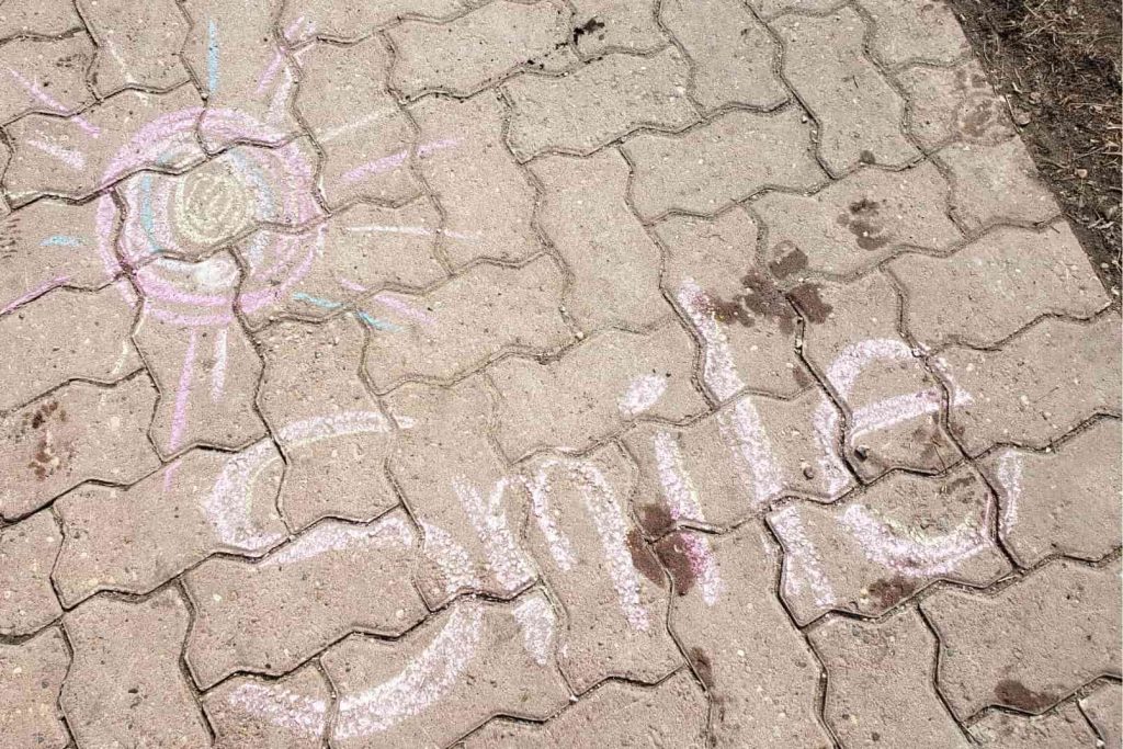 smile written with chalk on the sidewalk