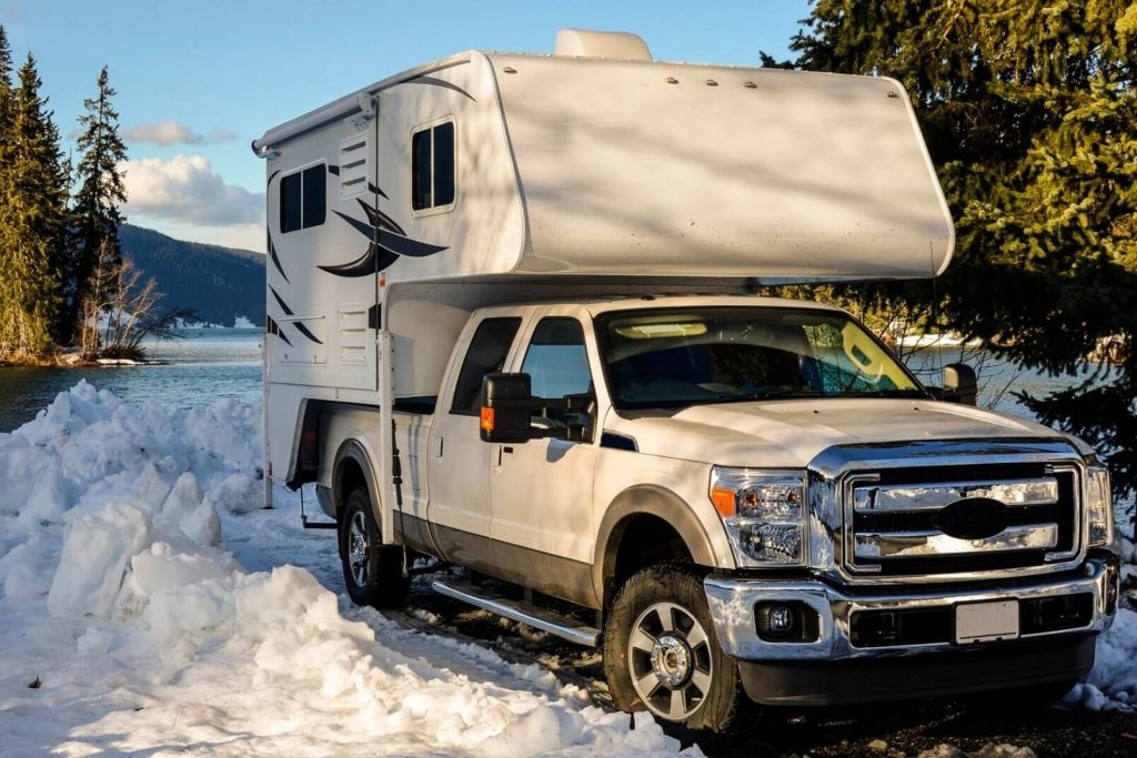 A camper RV parked in a snowy campsite