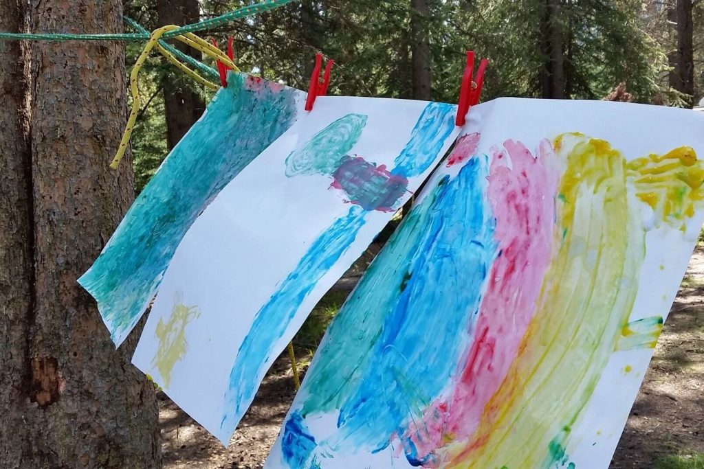 kids paintings hanging in the backyard line to dry