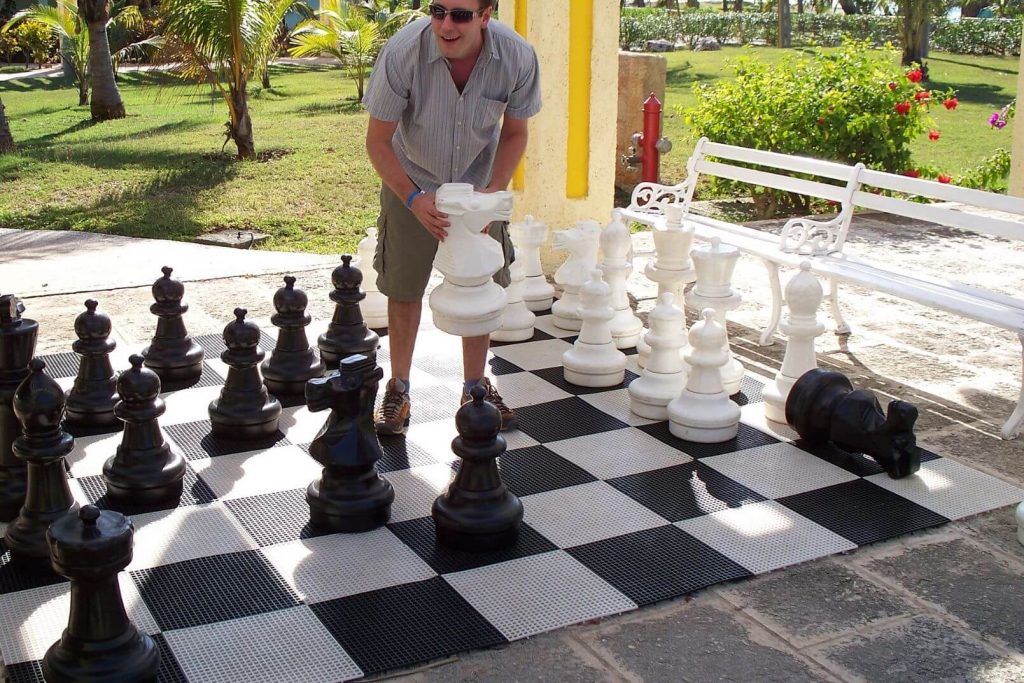 a man playing with a giant outdoor chess set game