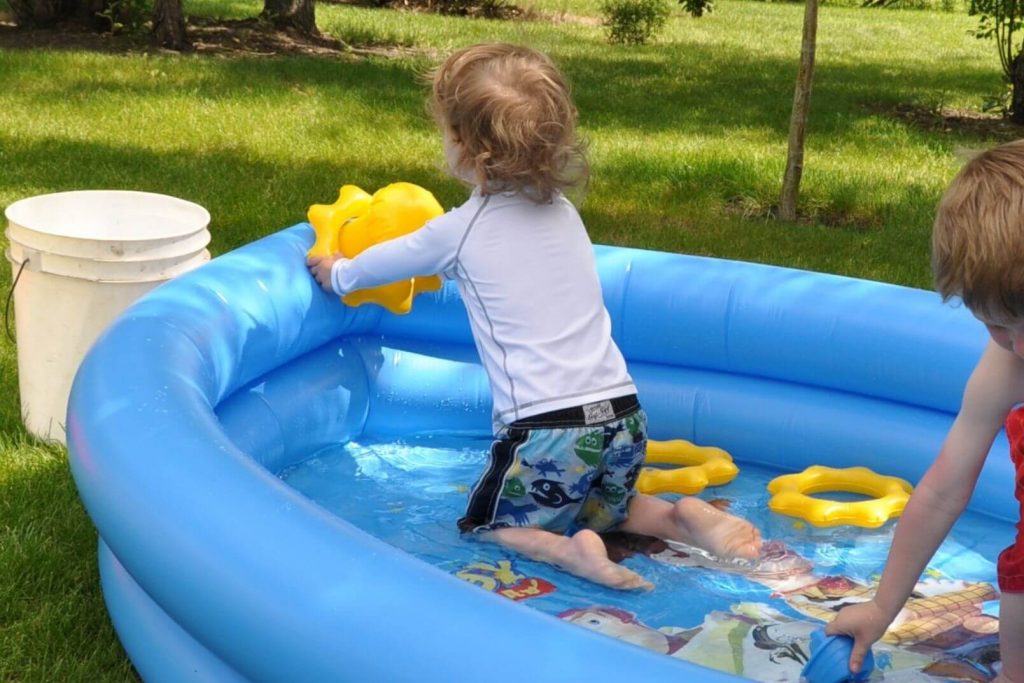 toddler playing in a kiddie pool