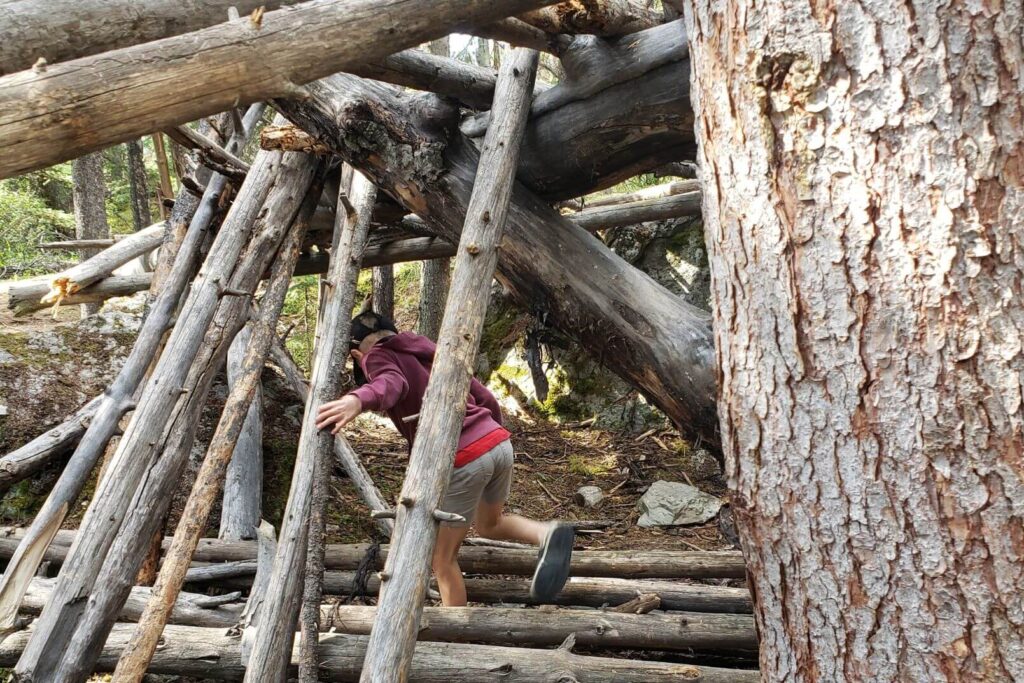 child playing in a lean-to fort found at Wabasso Campground in Jasper National Park