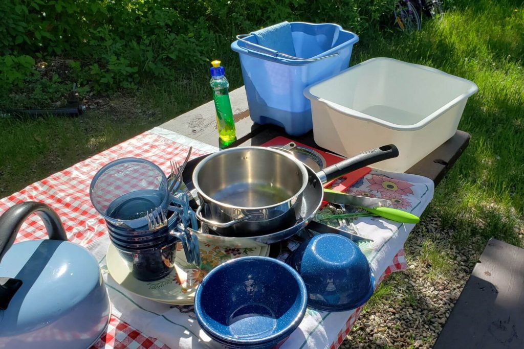 Clean dishes set out to dry after washing them at the campsite