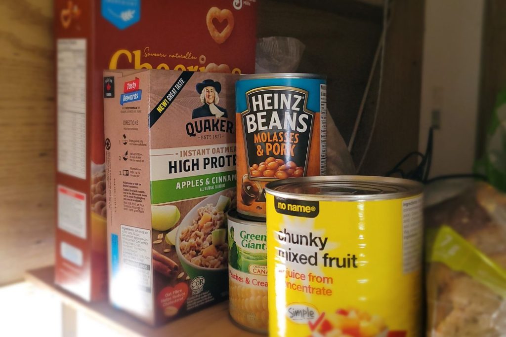 Cereal, oatmeal, canned foods on a pantry shelf inside an RV camper